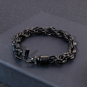 Détail d'un bracelet gourmette noire punk torsadée avec fermoir à crochet sur socle gris