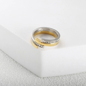 Close-up of interlocking two-tone titanium steel rings in gold and diamond-set silver