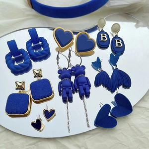 Detailed view of Klein blue velvet earrings in various heart and bear designs on mirror