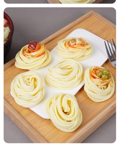 Modèles réalistes de nids de spaghetti avec viande et sauce présentés sur un plateau en bois