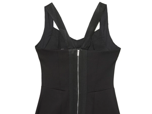 Detalle de vestido negro con escote en V, tirantes cruzados y cremallera de metal