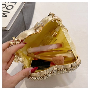 Interior view of gold heart rhinestone evening clutch showing capacity for cosmetics