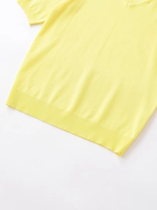 Macro detail of the yellow short-sleeved knitted top with ribbed hem and cuffs