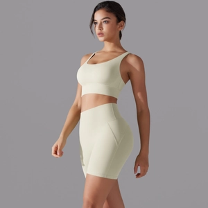 Dettaglio dei pantaloncini sportivi senza cuciture a vita alta crema e set reggiseno yoga