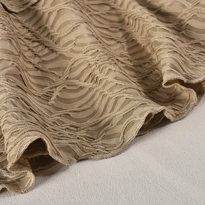 Vue détaillée du tissu mesh plissé doré champagne avec texture ondulée et brillance