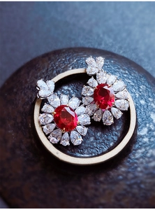 Dettaglio di orecchini a fiore con tormalina rossa e pavé di diamanti lucenti