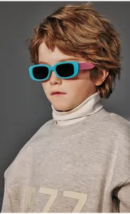 Close-up of polarized children's sunglasses with blue frames and pink temples on a child model