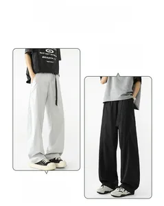 Detalle de pantalones anchos en gris claro y negro con cordón ajustable y corte holgado casual
