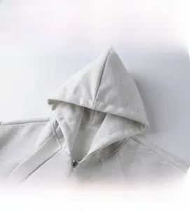 Detailansicht des Kapuzenausschnitts und Metallreißverschlusses am grauen Oversize-Hoodie