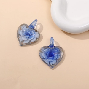 Detail view of two glass heart pendants featuring delicate blue floral patterns