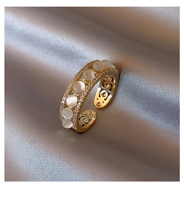 Detail of adjustable gold ring with cat-eye stones and micro-pave zircons on silk