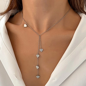 Vue détaillée d'un collier multi-rangs avec pendentifs cœur en or rose sur mannequin