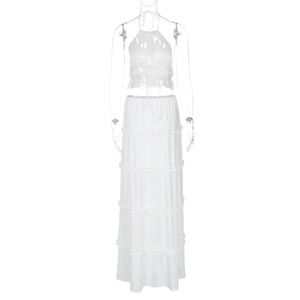 Detail view of white two-piece set featuring a halter crop top and tiered maxi skirt