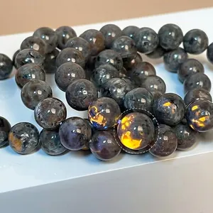 Punk style fire stone beaded bracelet showing orange fluorescence under UV light on white stand