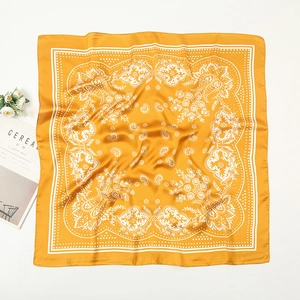 Detail of bohemian yellow paisley silk-like square scarf with fine stitched edges