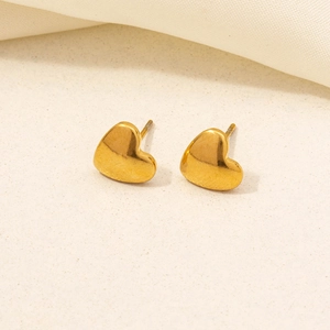 Detailed close-up of 304 stainless steel gold heart stud earrings on soft fabric