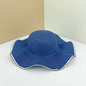 Navy blue woven straw hat with wide wavy brim and elegant black and white stitched edges