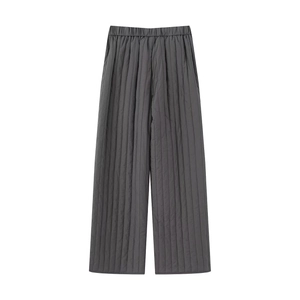 Close-up of dark grey quilted pants featuring vertical stitching and elastic waistband