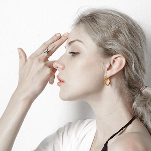 Minimalist knot golden earrings and silver hollow ring set worn by model for daily style