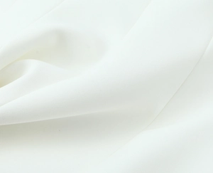 Detailed macro shot of premium white woven fabric texture with soft drapery for top