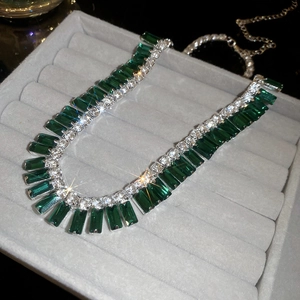 Macro shot of silver tassel necklace with emerald green zircons and shimmering diamonds