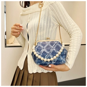 Blue denim crossbody bag with white diamond pattern, pearl handle, and gold chain strap