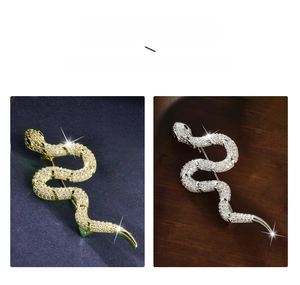 Detailed view of gold and silver snake brooches with micro-pave cubic zirconia settings