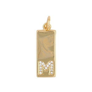 Macro detail of a gold rectangular pendant featuring a sparkling zircon-set letter M