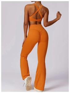 Detail of orange yoga set featuring high waist scrunch butt leggings and cross back sports bra
