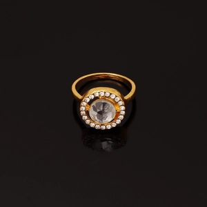 Macro shot of a golden ring featuring a large clear centerpiece surrounded by small crystals