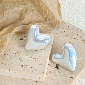 Elegant silver heart-shaped earrings on stone base with a modern minimalist metal finish