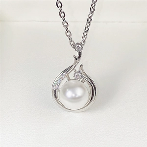Detail of baroque pearl pendant with silver metal base and sparkling micro crystals
