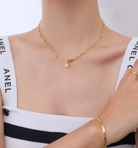 Detail of 18k gold plated stainless steel star pendant necklace and bracelet on model