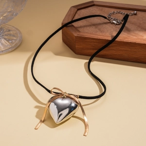 Minimalist heart pendant necklace with golden bow detail on black cord for women