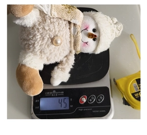 Close-up showing a plush Christmas snowman doll weighing 45g on a digital scale