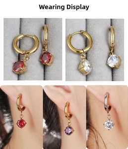 Macro shot of cubic zirconia drop earrings in red, clear, and purple on model's ear