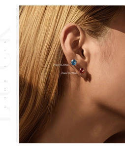 Detailed close-up of 7mm round firework cut stud earrings on model in gold plating