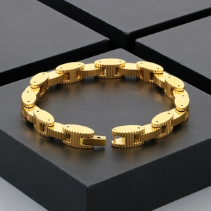 Luxury gold watch strap bracelet with textured oval links on a black pedestal stand