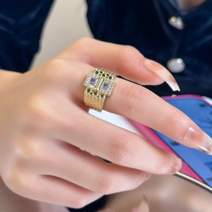 Detailed close-up of gold wall-pattern ring with double square-cut crystal accents