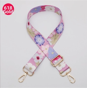 Detail of floral ethnic fabric strap with adjustable golden metal buckle and lobster clasp