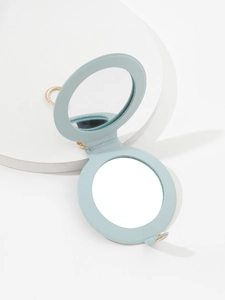 Macro detail of a light blue PU leather mini makeup mirror with gold keychain ring