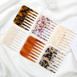 Flat lay of six wide-tooth acetate hair combs in various marble and tortoiseshell patterns