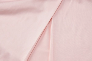 Macro close-up of pink fabric texture showing soft folds and smooth material quality