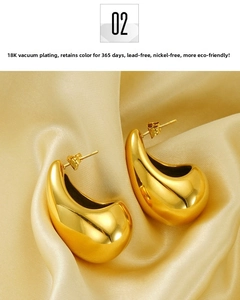 Detail of 18K gold plated large teardrop earrings on golden silk background
