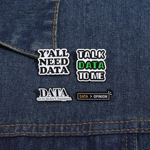 Detail of four DATA themed enamel pins with funny slogans on denim background
