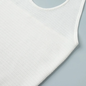 Close-up of white knitted halter top showing fine ribbed texture and round neckline