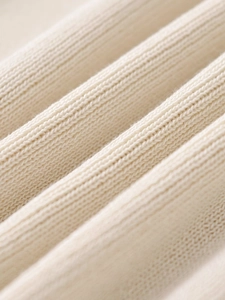 Close-up of the beige ribbed knit fabric texture on this long sleeve cardigan sweater