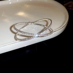Macro shot of silver crisscross bracelet with faux pearls and sparkling zirconia stones