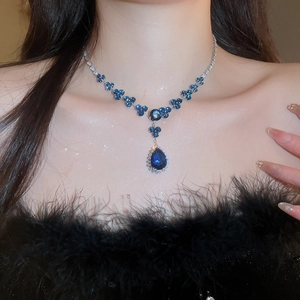 Detail of silver necklace with blue zircon flowers and large teardrop gemstone pendant