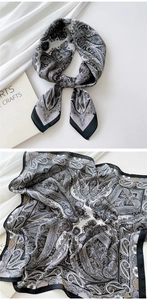 Detail of paisley pattern silk scarf with black and white elegant fabric texture